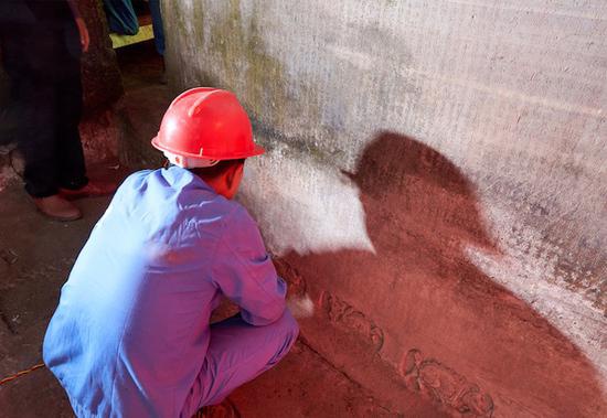 相关工作人员正在对藏经洞经文进行专业除尘保护